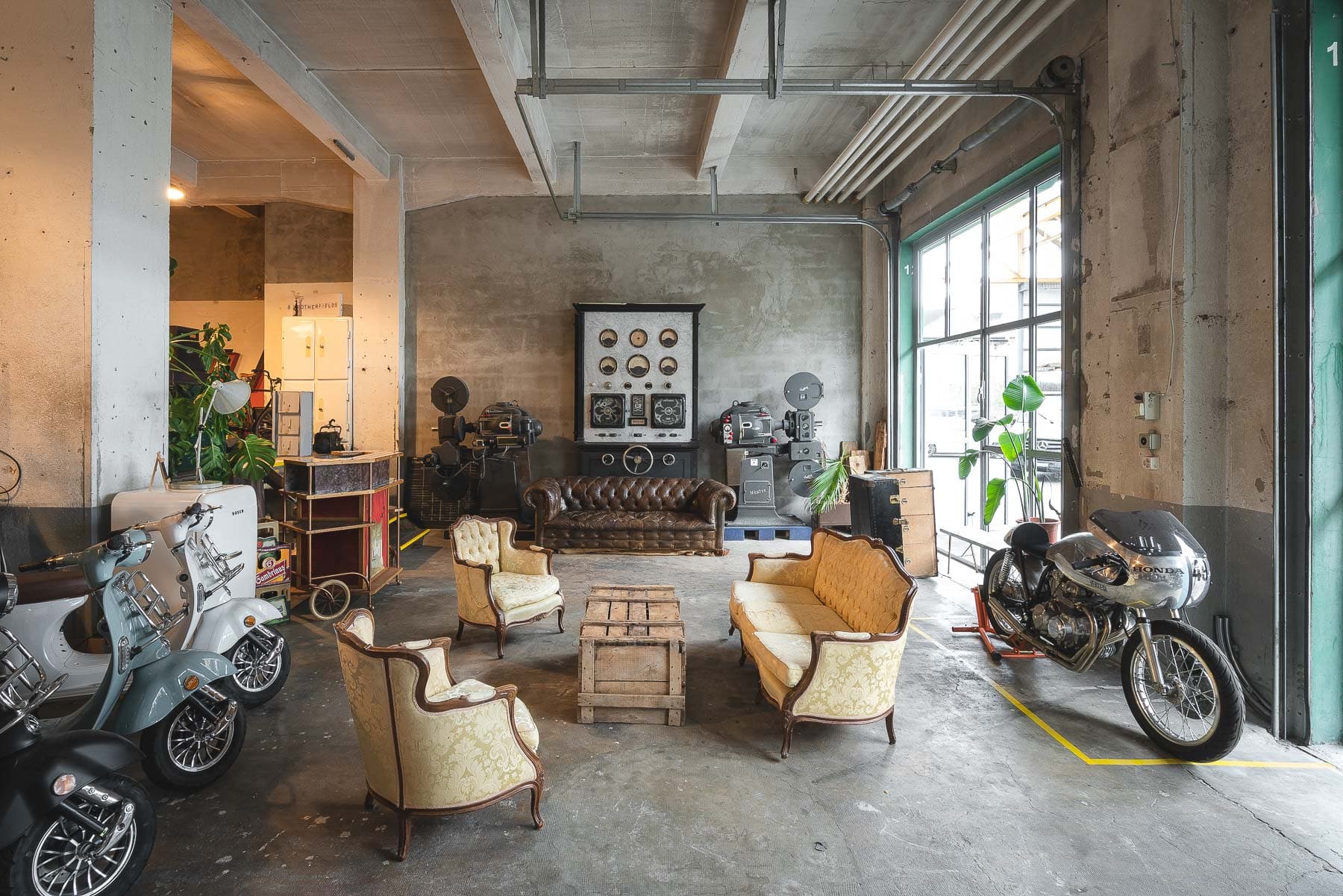 Intérieur d'entrepôt de 240m² mettant en valeur la lumière naturelle à travers de grandes fenêtres, plafond industriel exposé et espace ouvert polyvalent parfait pour événements privés, expositions et célébrations à Lausanne